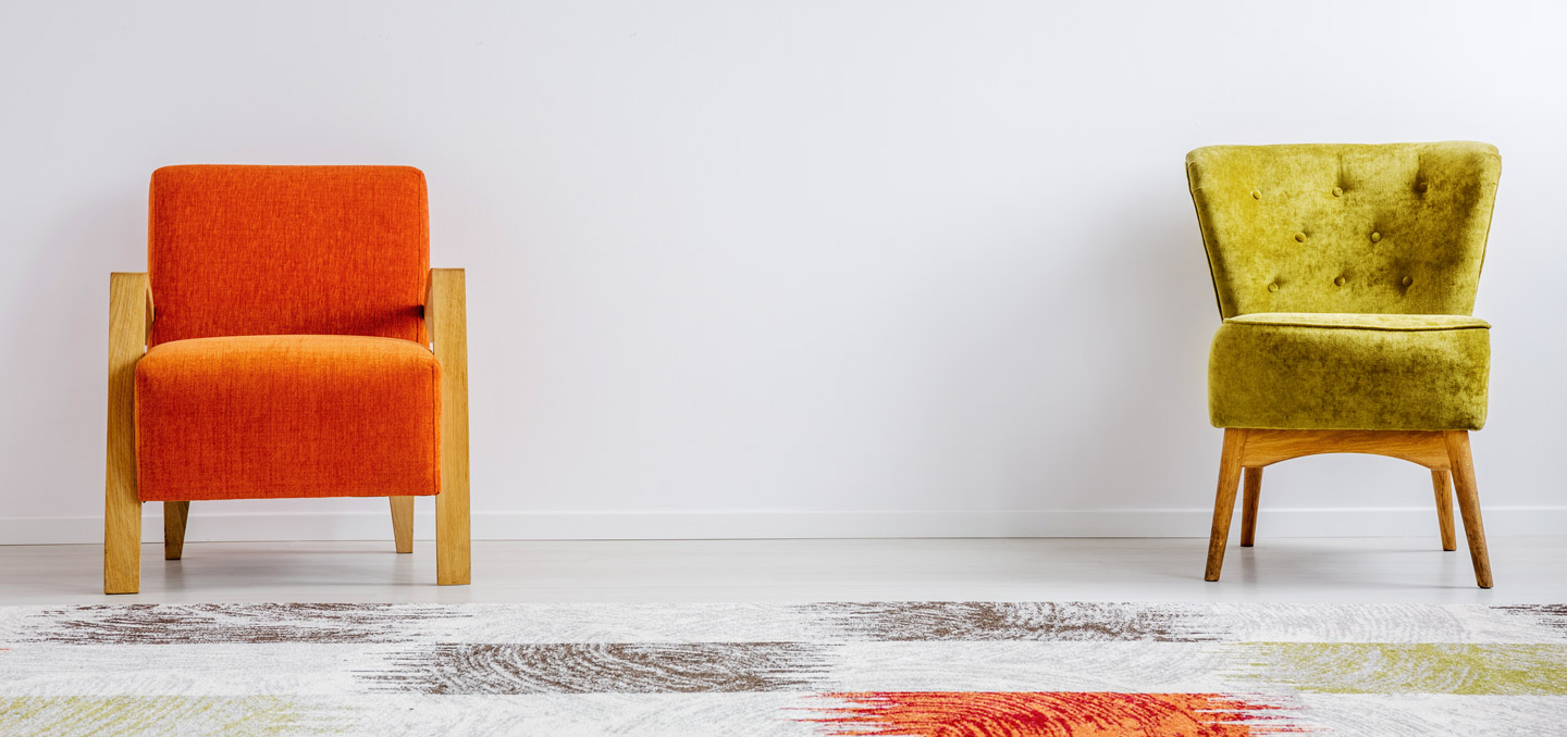 Zwei Sessel stehen vor weißer Wand