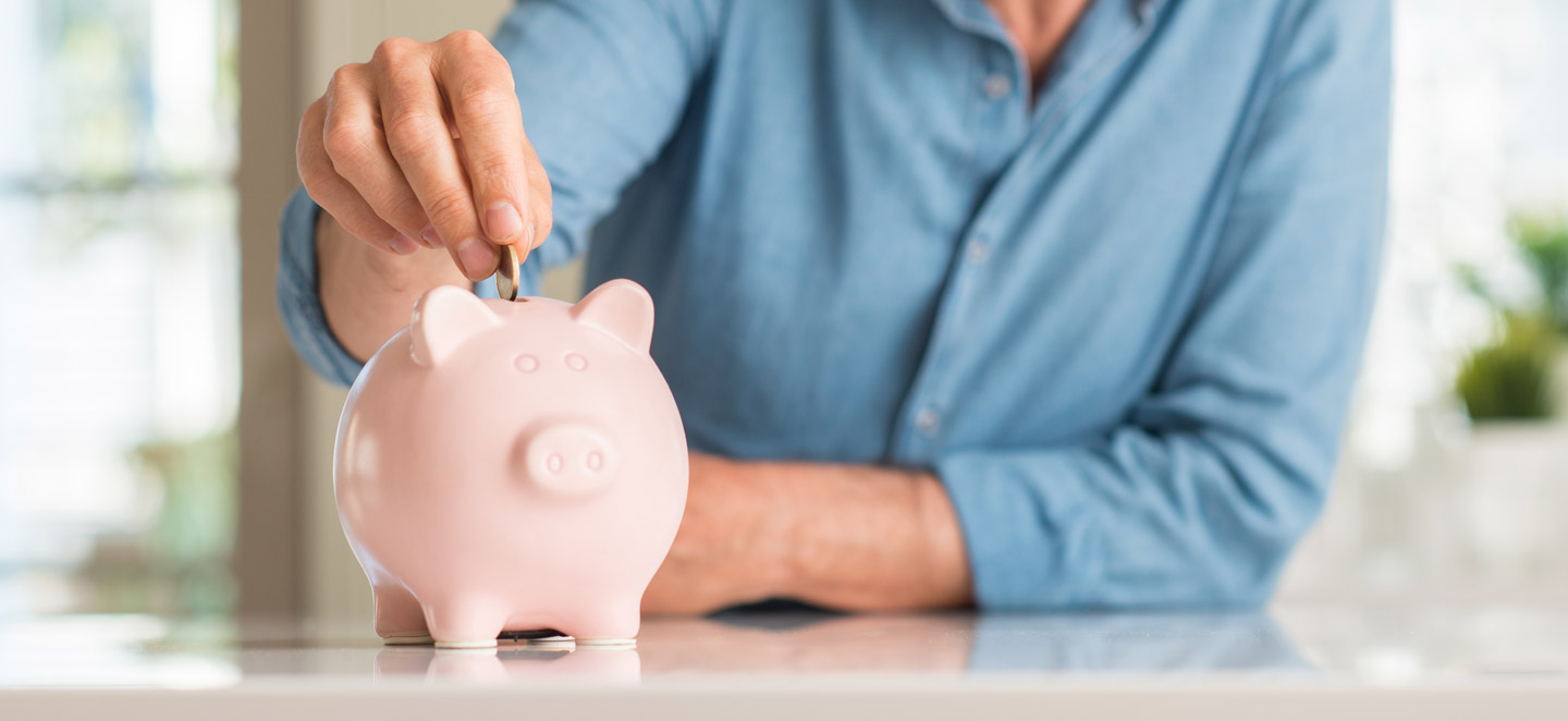 Mann tut Geld in Sparschwein