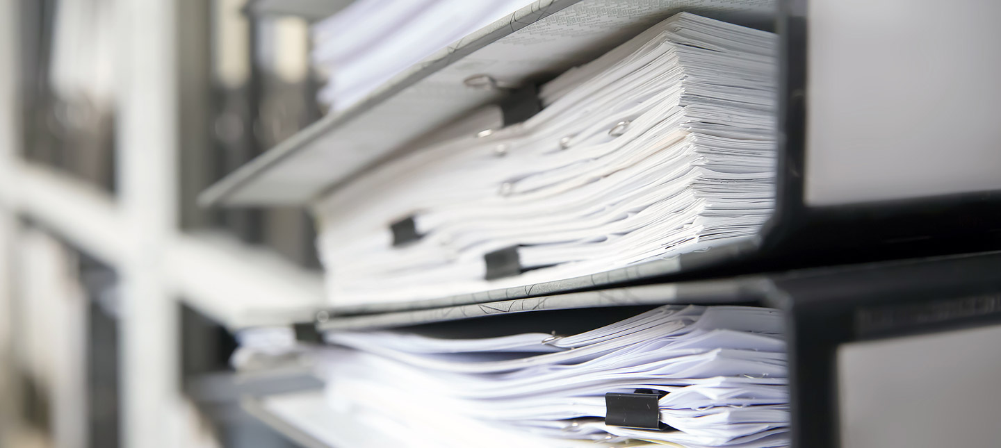 Ordner mit Dokumenten in einem Regal