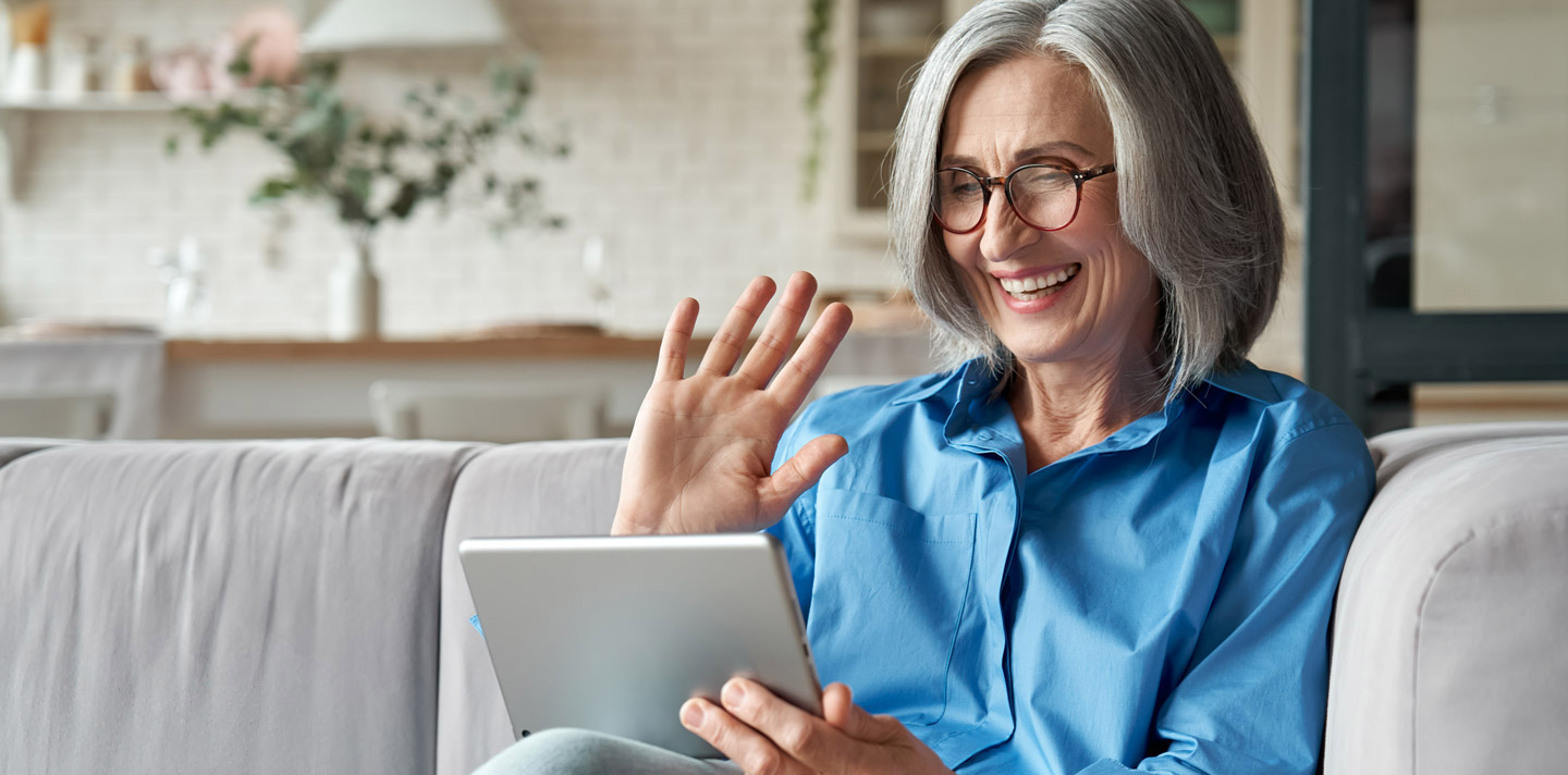 Frau nutzt Tablet auf Sofa